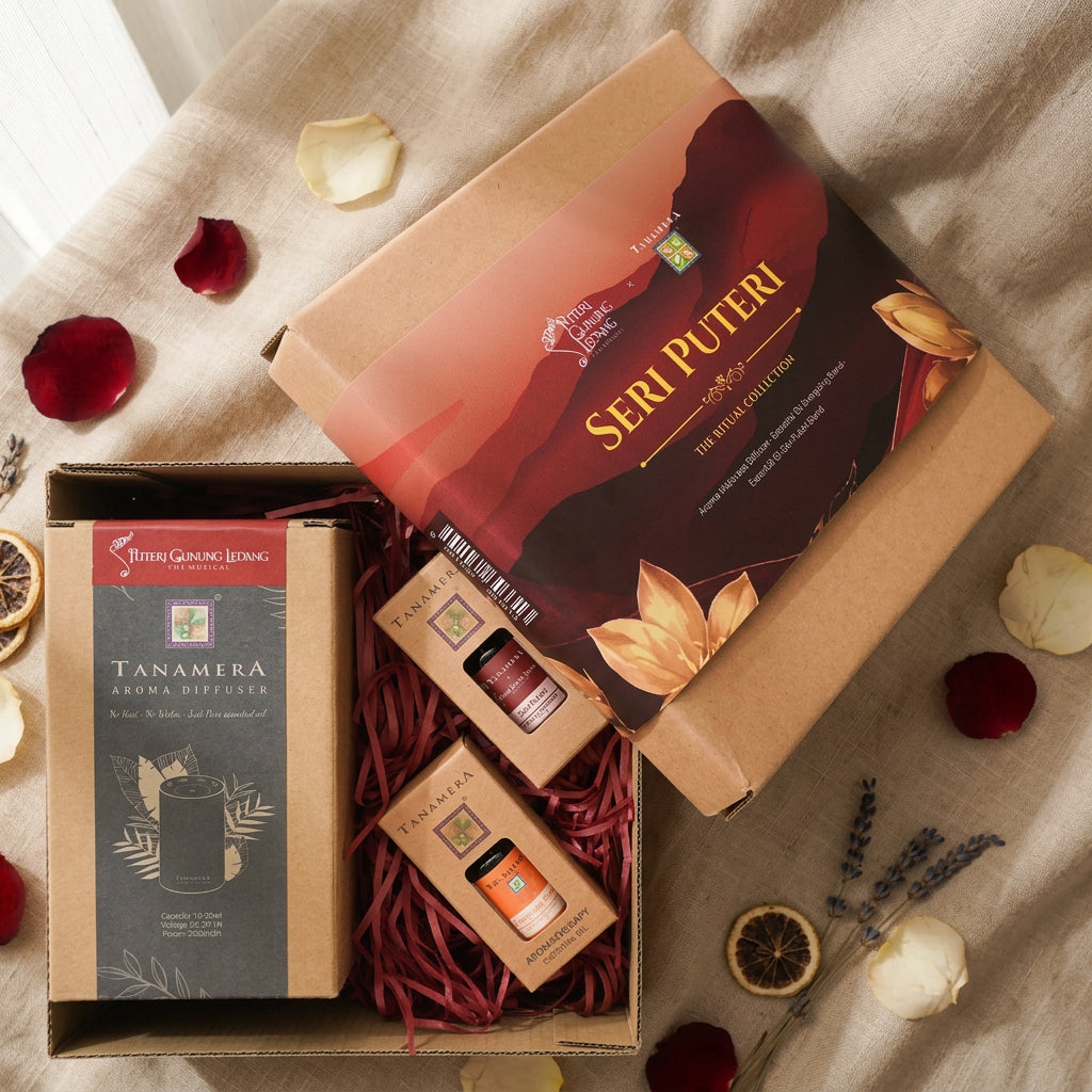A Seri Puteri essential oil and aroma diffuser gift set by Tanamera, shown open on a white background. The set includes a large kraft paper box with a red and black label, a Tanamera aroma diffuser box, and two small amber glass diffuser bottles nestled in red paper shred.