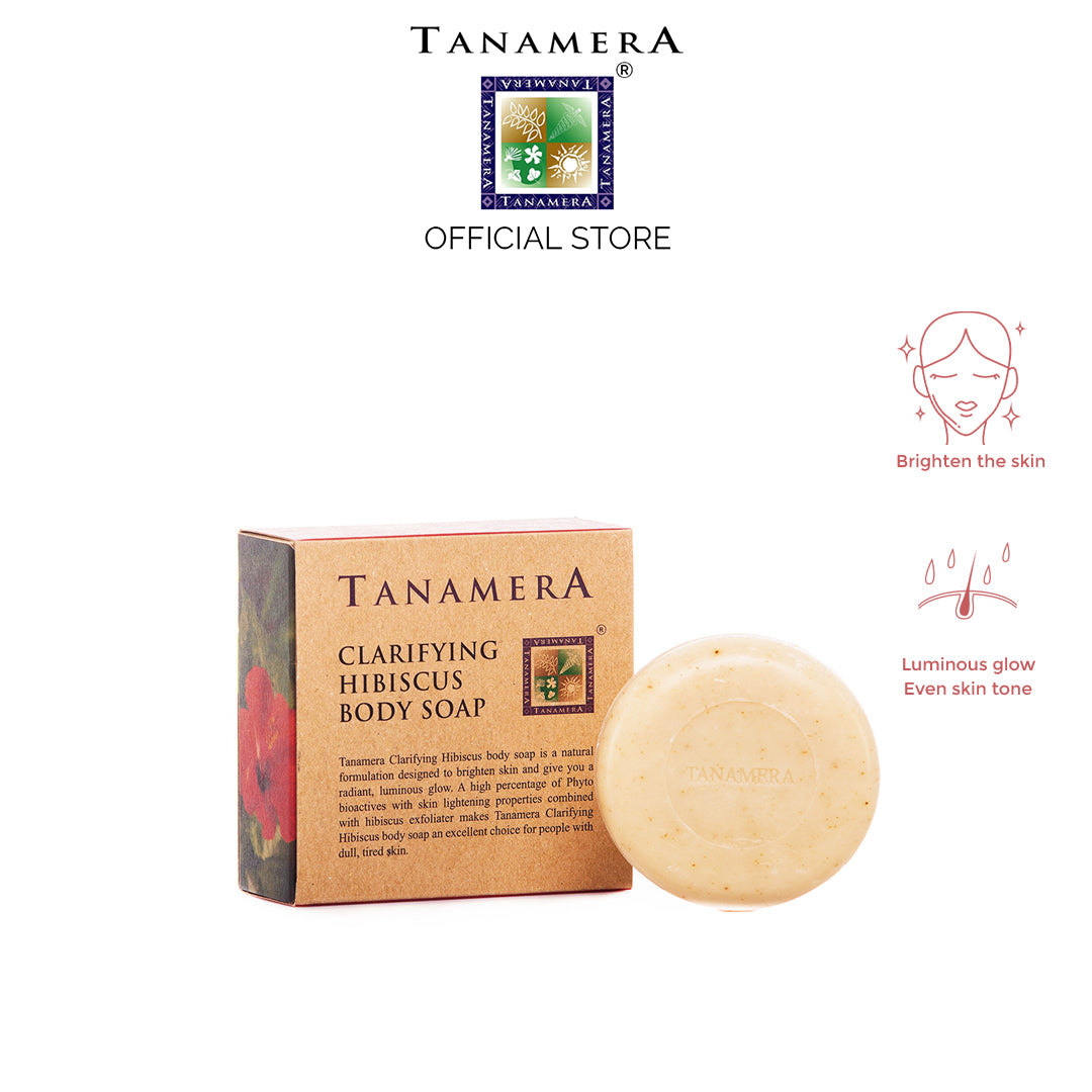 A bar of Clarifying Hibiscus Body Soap with its packaging, which is labeled 'Tanamera Official Store'. The soap is round and beige in color, while the packaging is beige with red and green floral graphics and text.